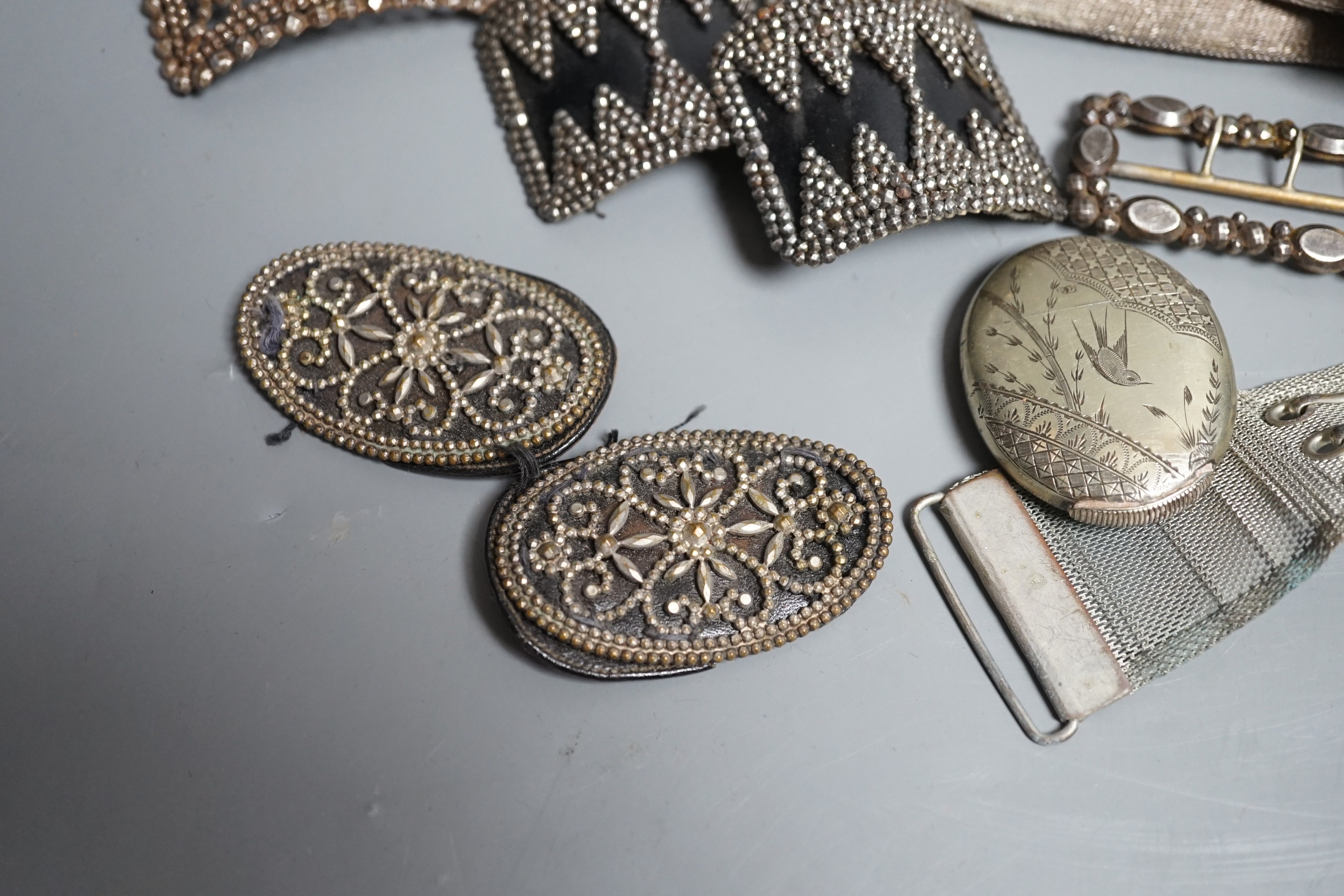 An Indian metal belt, four assorted metal shoe buckles and an aesthetic engraved silver plated vesta case.